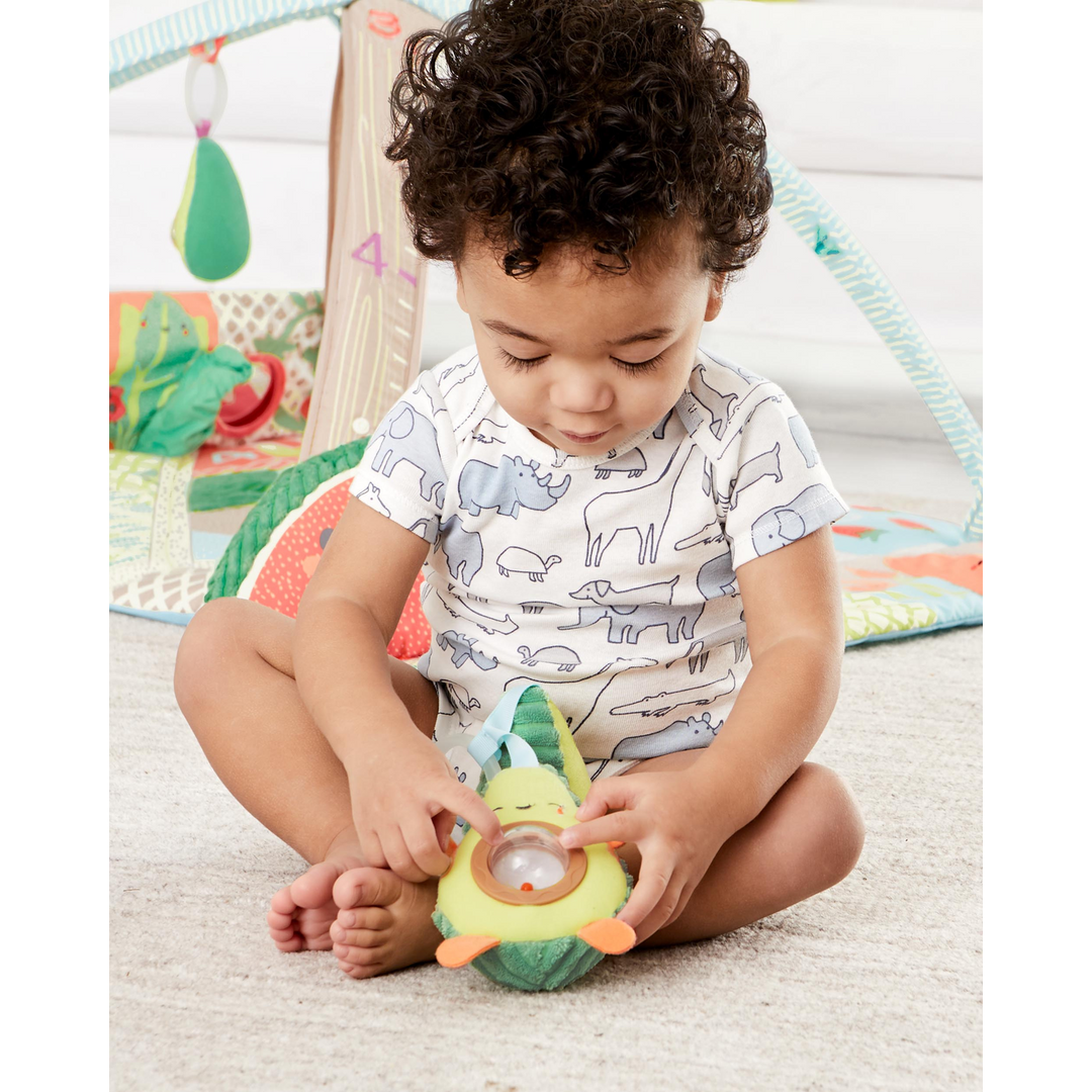 Plush avocado stroller toy with peek-a-boo rattle pit