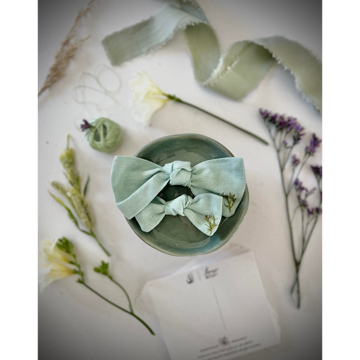 Embroidered linen bow with alligator clip attachment