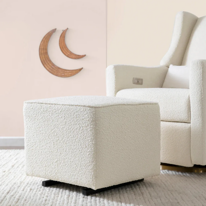 Babyletto ivory boucle gliding ottoman with gold-tone base